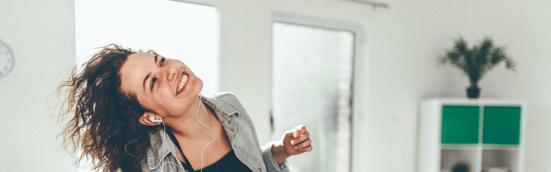 a woman dancing in the living room with headphones on