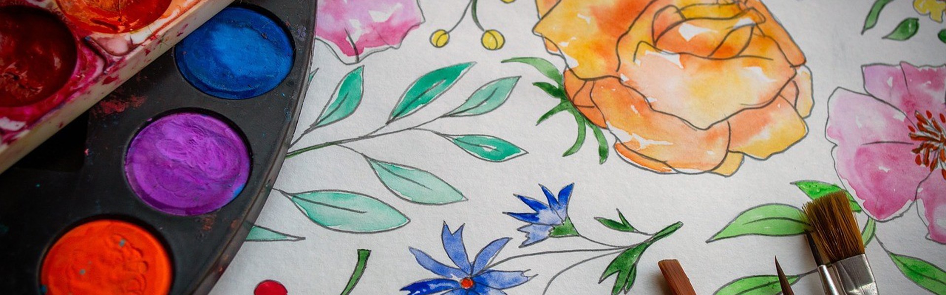 a close up of watercolour flowers and a watercolour paint pallet 