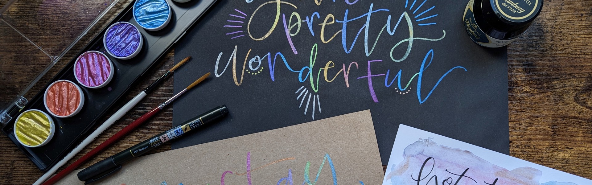 multicolour watercolour calligraphy on black card