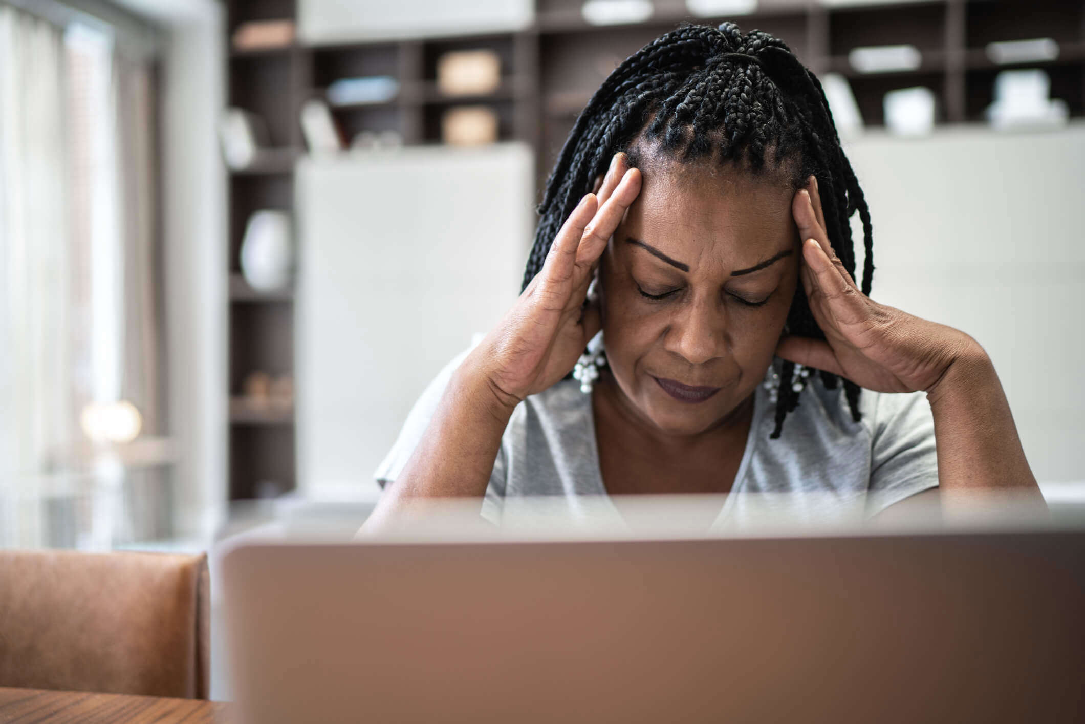 a woman with her head in her hands looking stressed