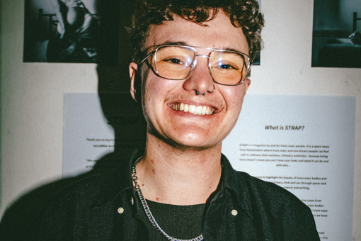 Photo of Ben smiling at the camera, will his photography in the background.
