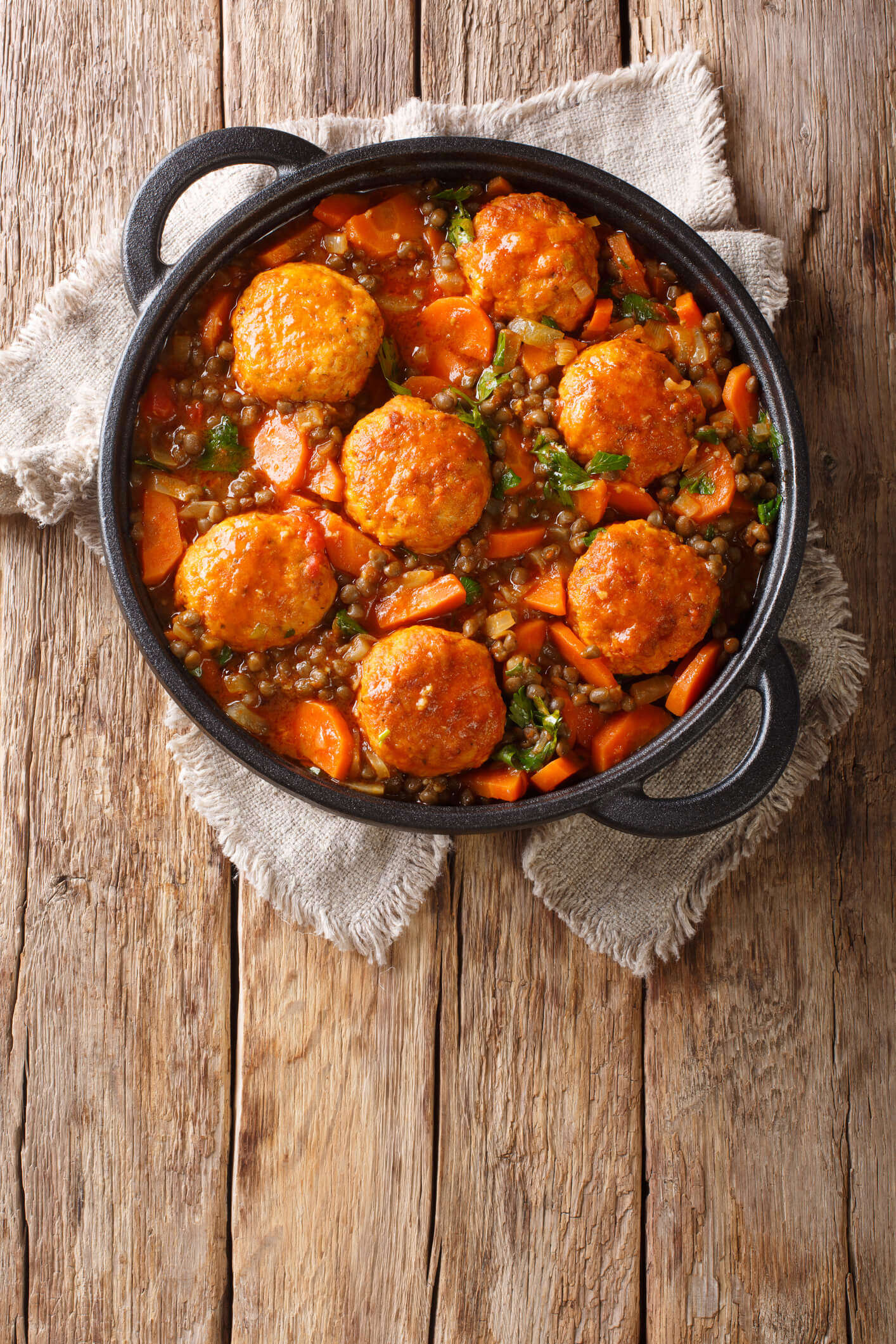 a homemade casserole in a black cooking pot on a wooden background