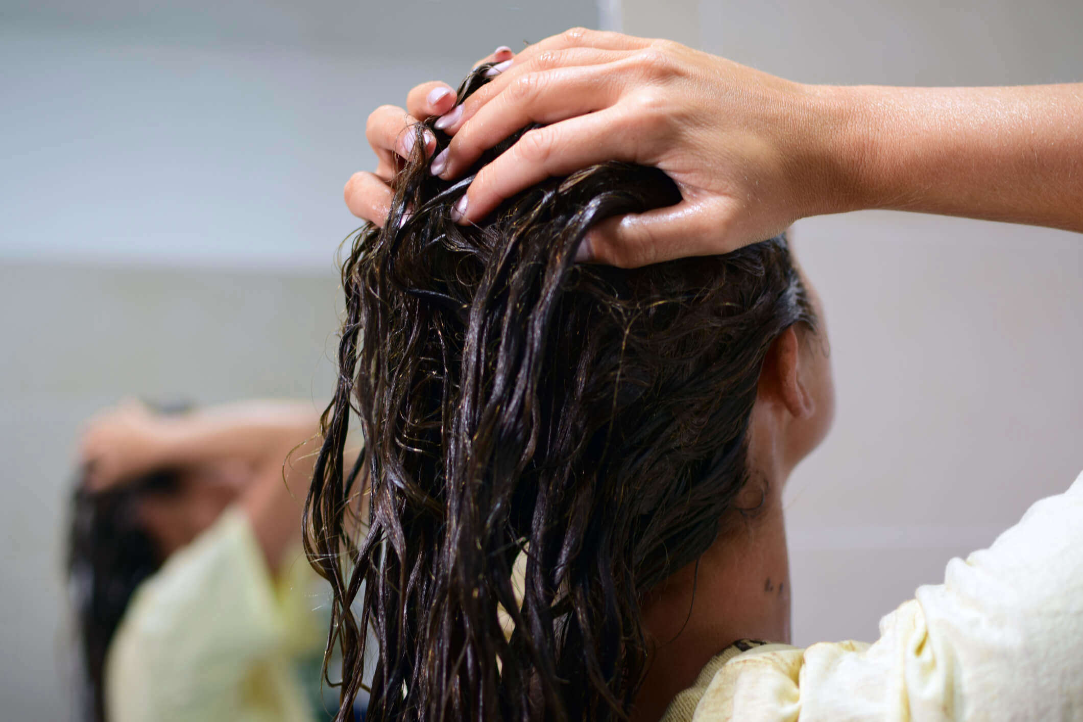 a woman lathering shampoo into her hair