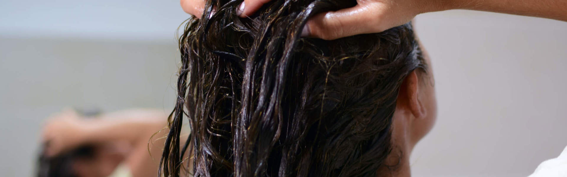 a woman lathering shampoo into her hair