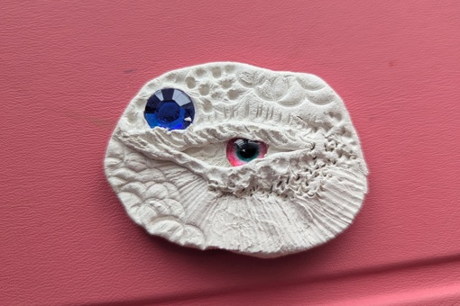 Main image: a dragon eye made out of air dry clay and craft bead eyes.