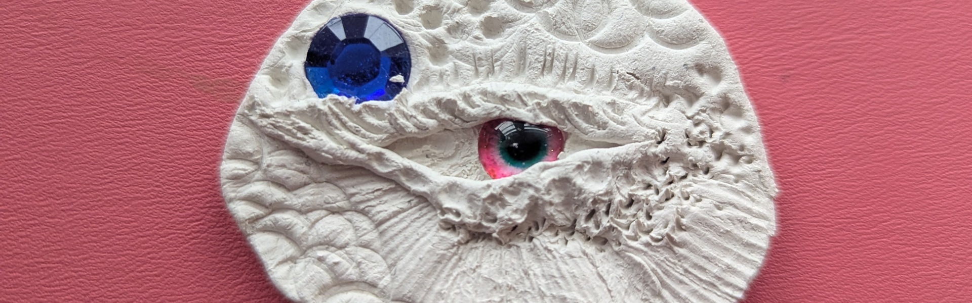 Main image: a dragon eye made out of air dry clay and craft bead eyes.