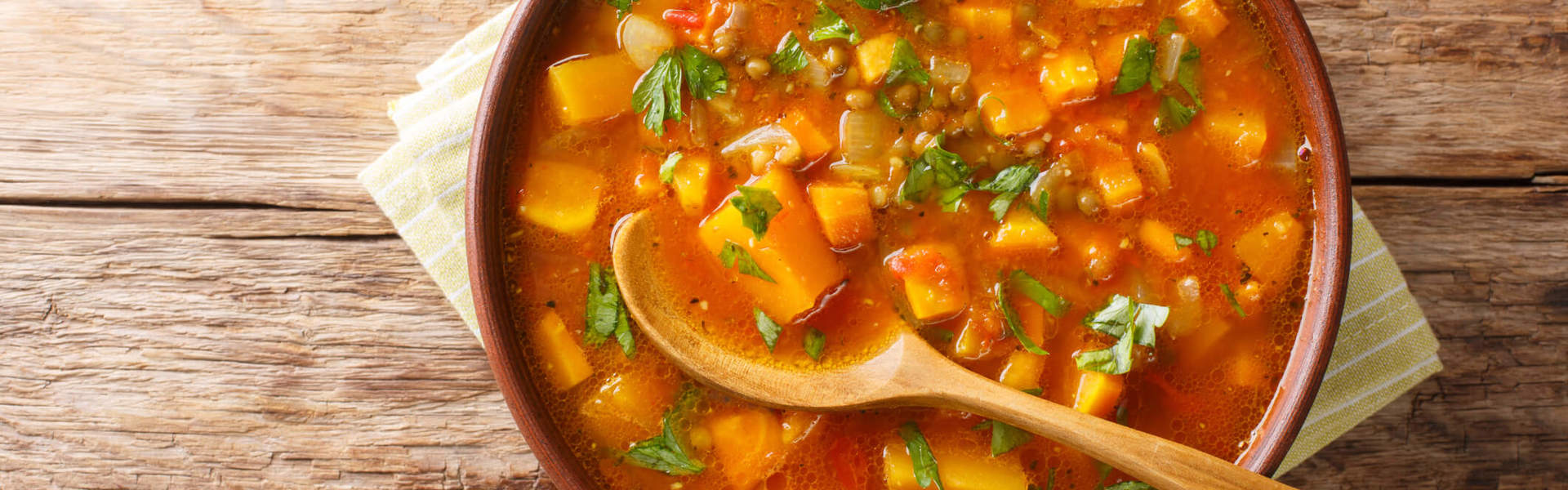 a bowl of homemade vegetable stew on a wooden background