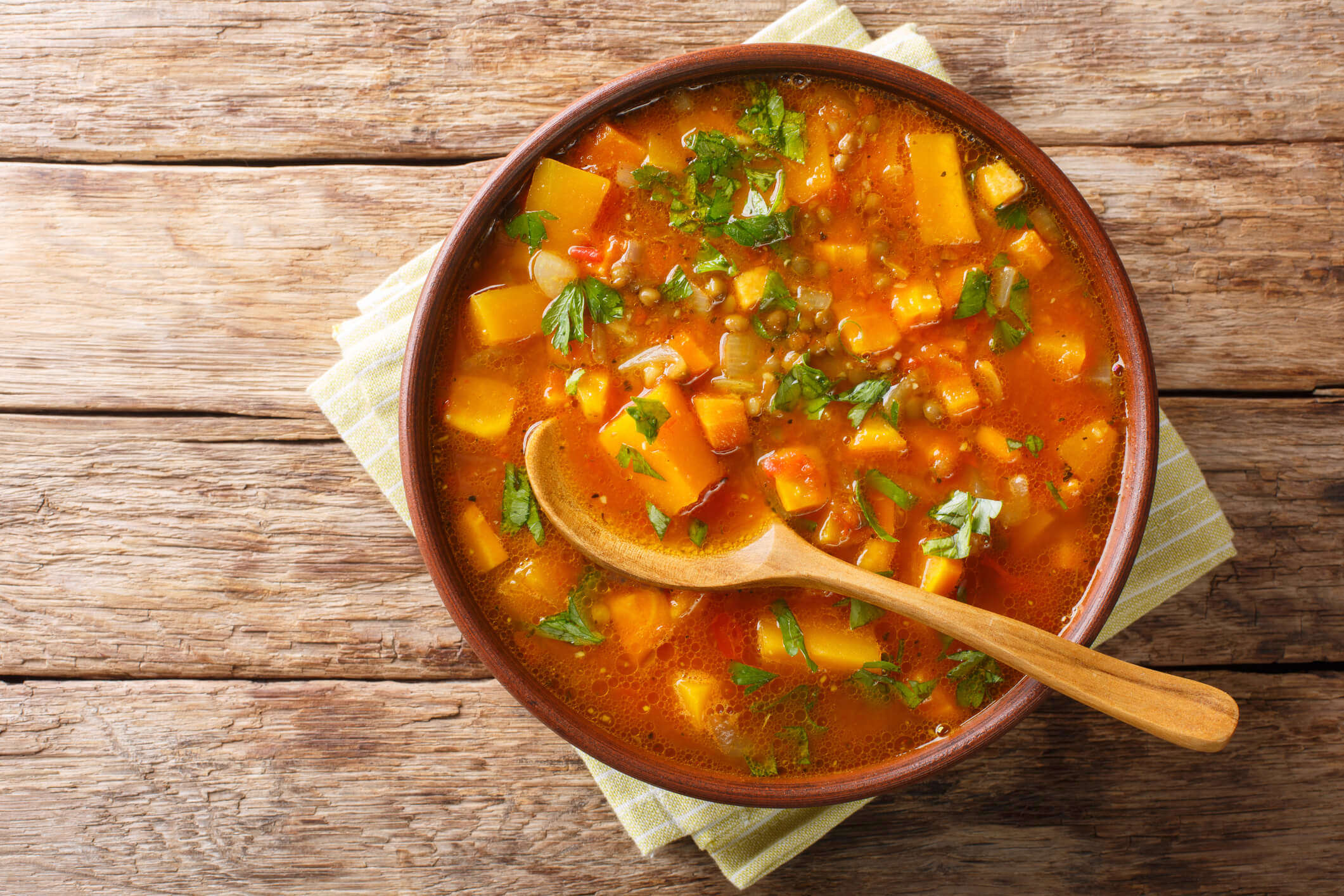 a bowl of homemade vegetable stew on a wooden background