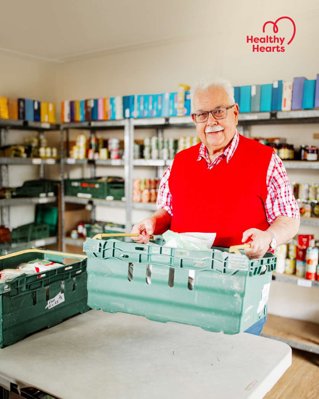 Main image: Nick, a man living with a heart condition, volunteering moving a box of items, with the healthy hearts campaign logo.