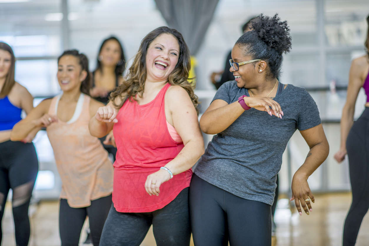 two women dancing and having fun in an exercise class