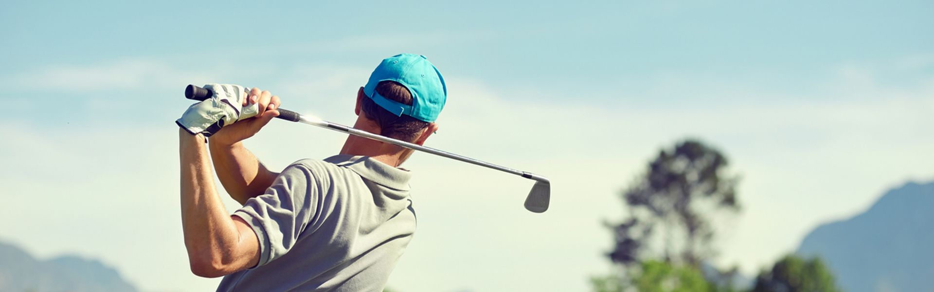 a picture of a man playing golf and completing a golf swing