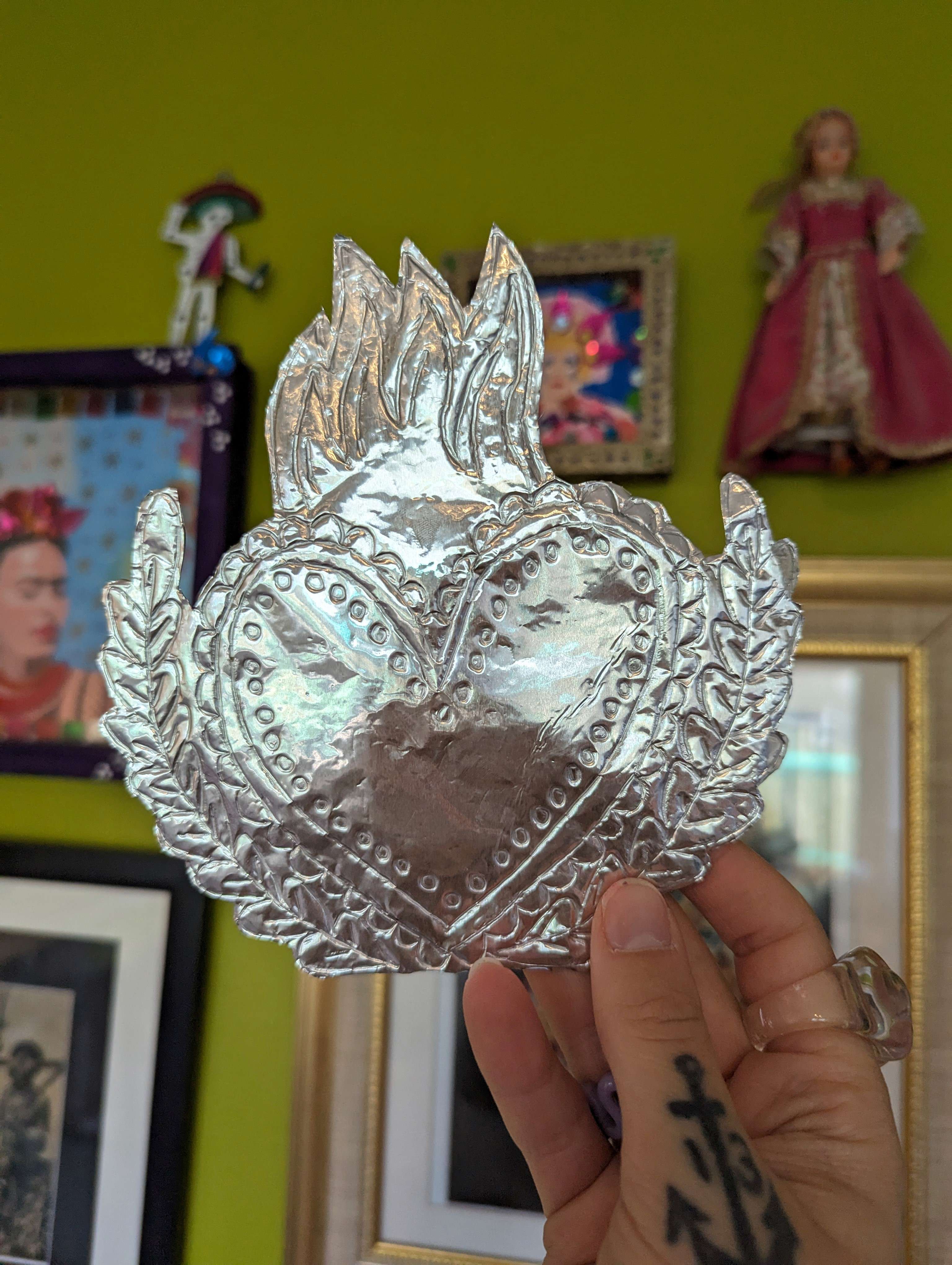 Mexican Inspired silver heart shaped foil decoration being held up 