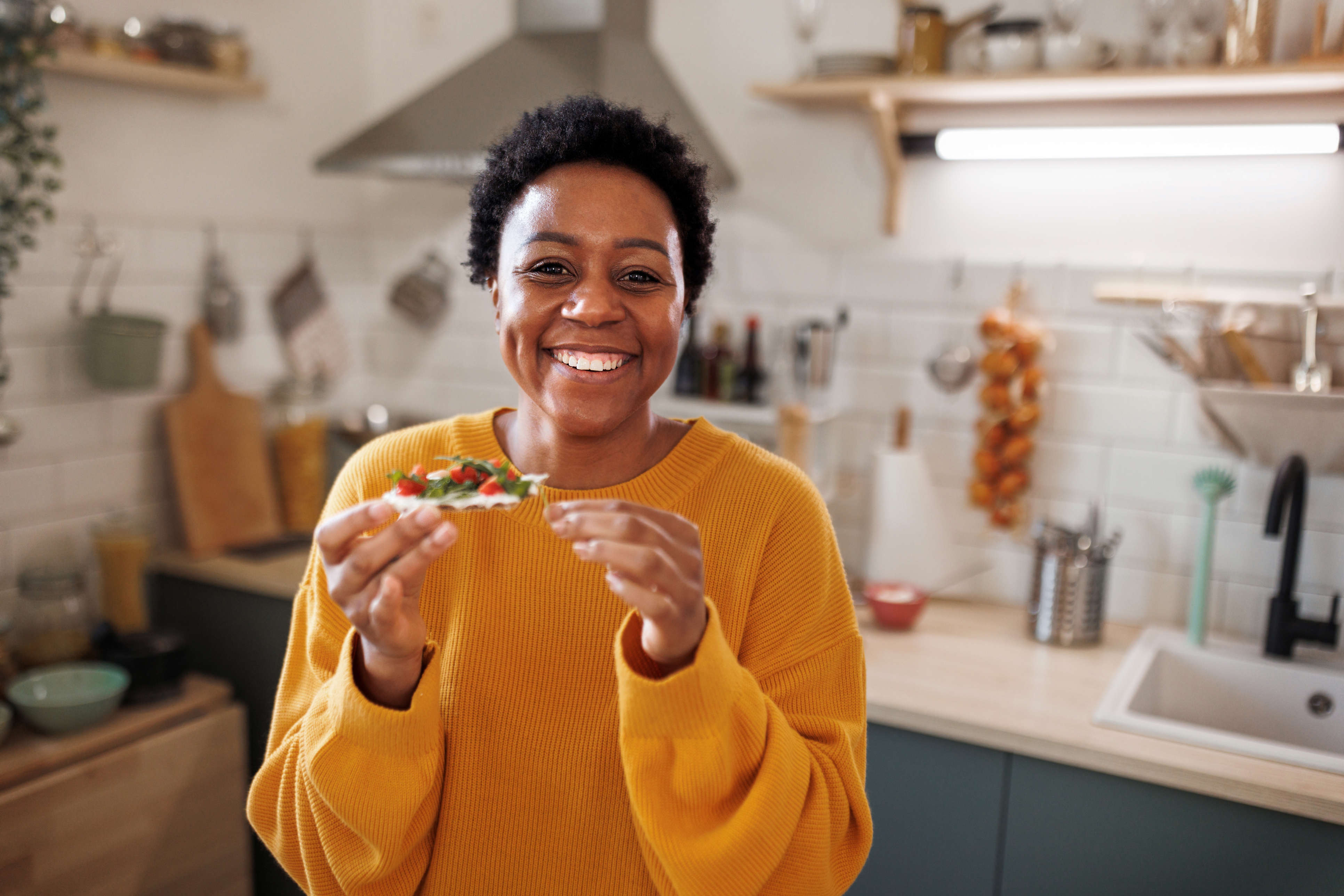 A woman eating some heathy snacks in her kitchen