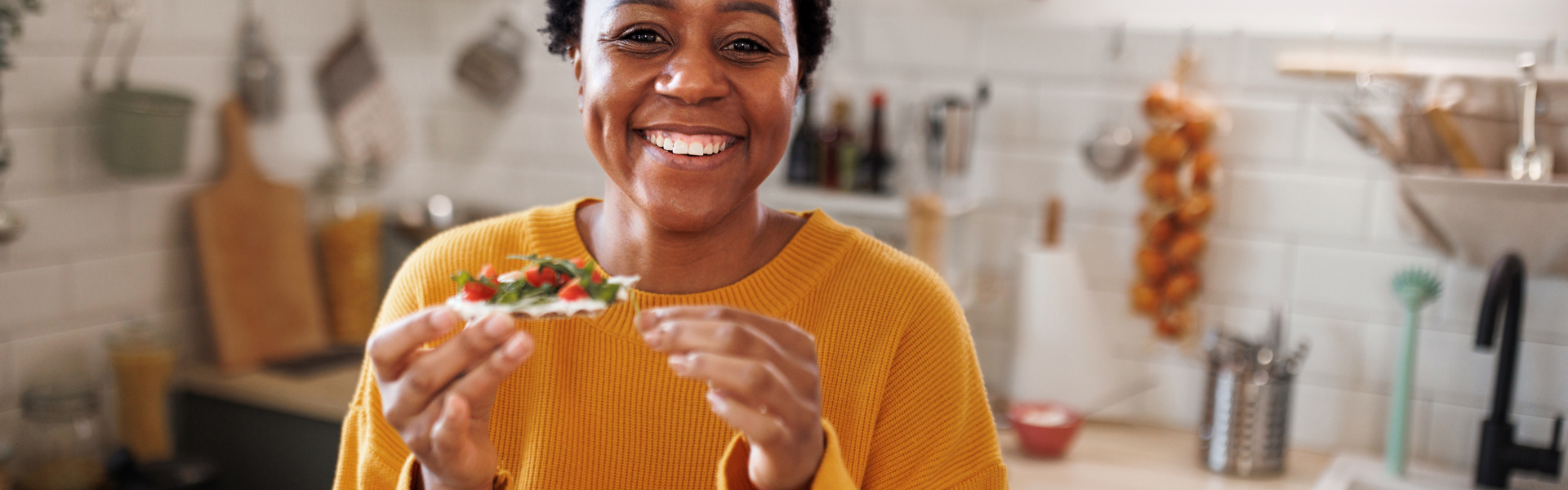 A woman eating some heathy snacks in her kitchen