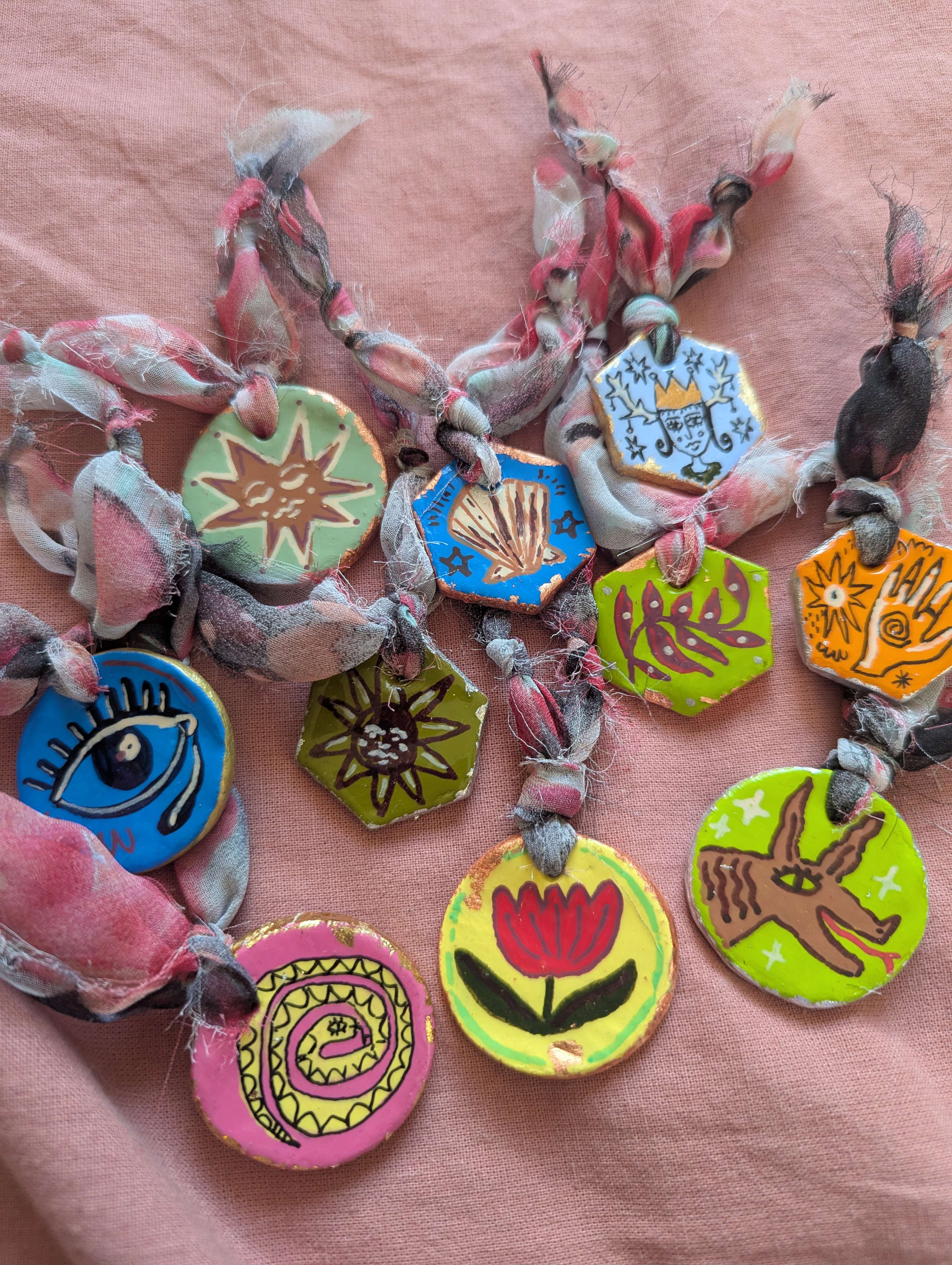 Main image: brightly hand painted, air dry clay pendants. 
