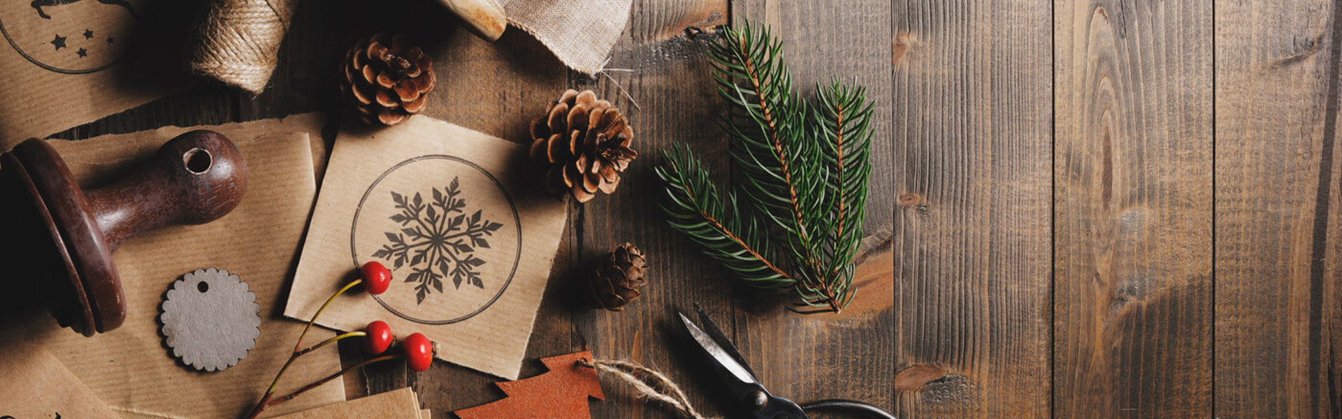 Seasonal foliage on a wooden table surrounded by craft tools