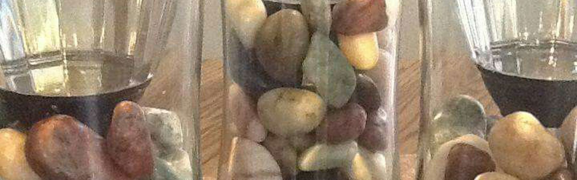 Main image: a selection of DIY solar lights in upcycled glass vases filled with pebbles for decoration. 
