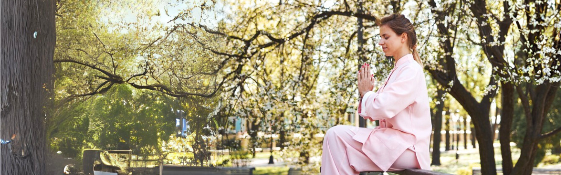 Main image: a woman sat on a bench in a park with her hand in a praying position, with trees all around her.