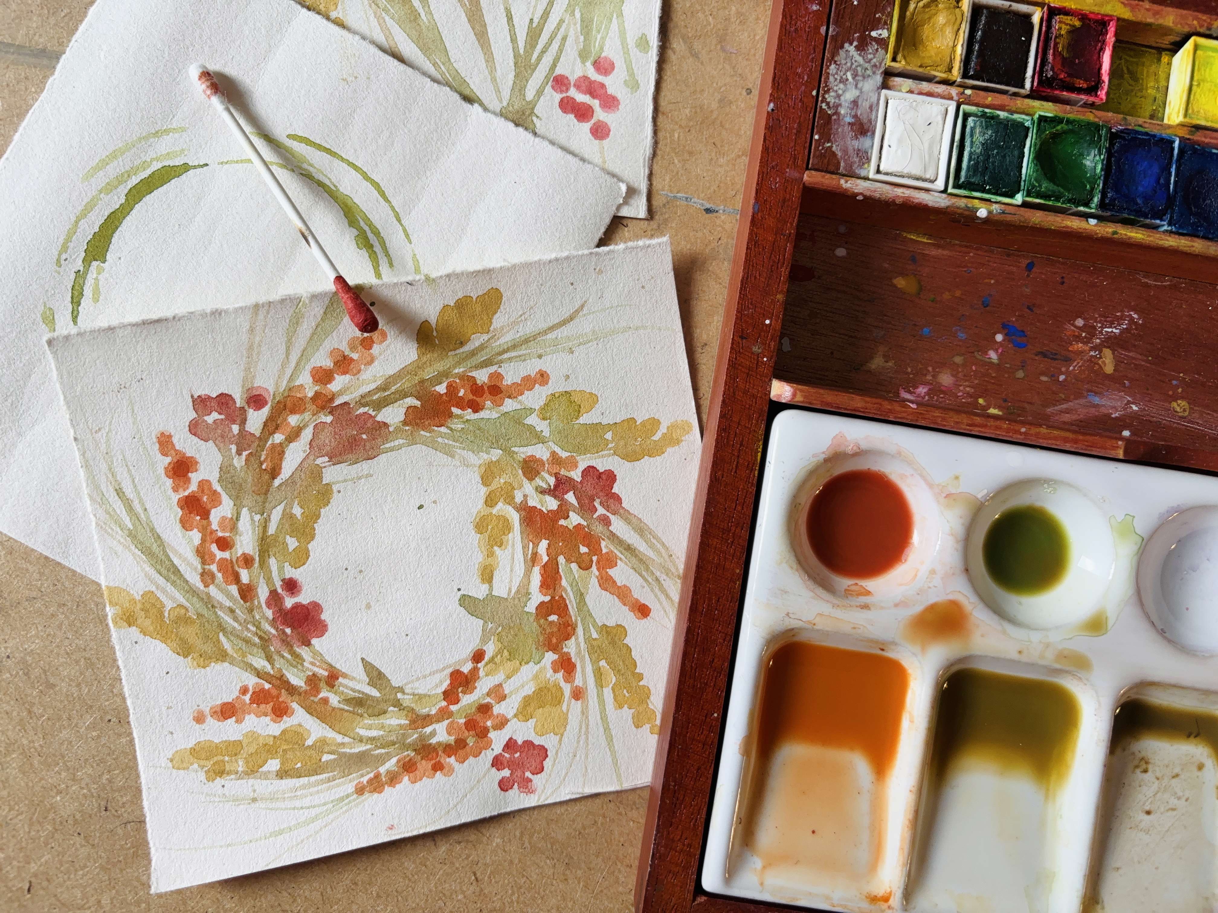 a close up of a watercolour pallet with orange red and yellow tone paints