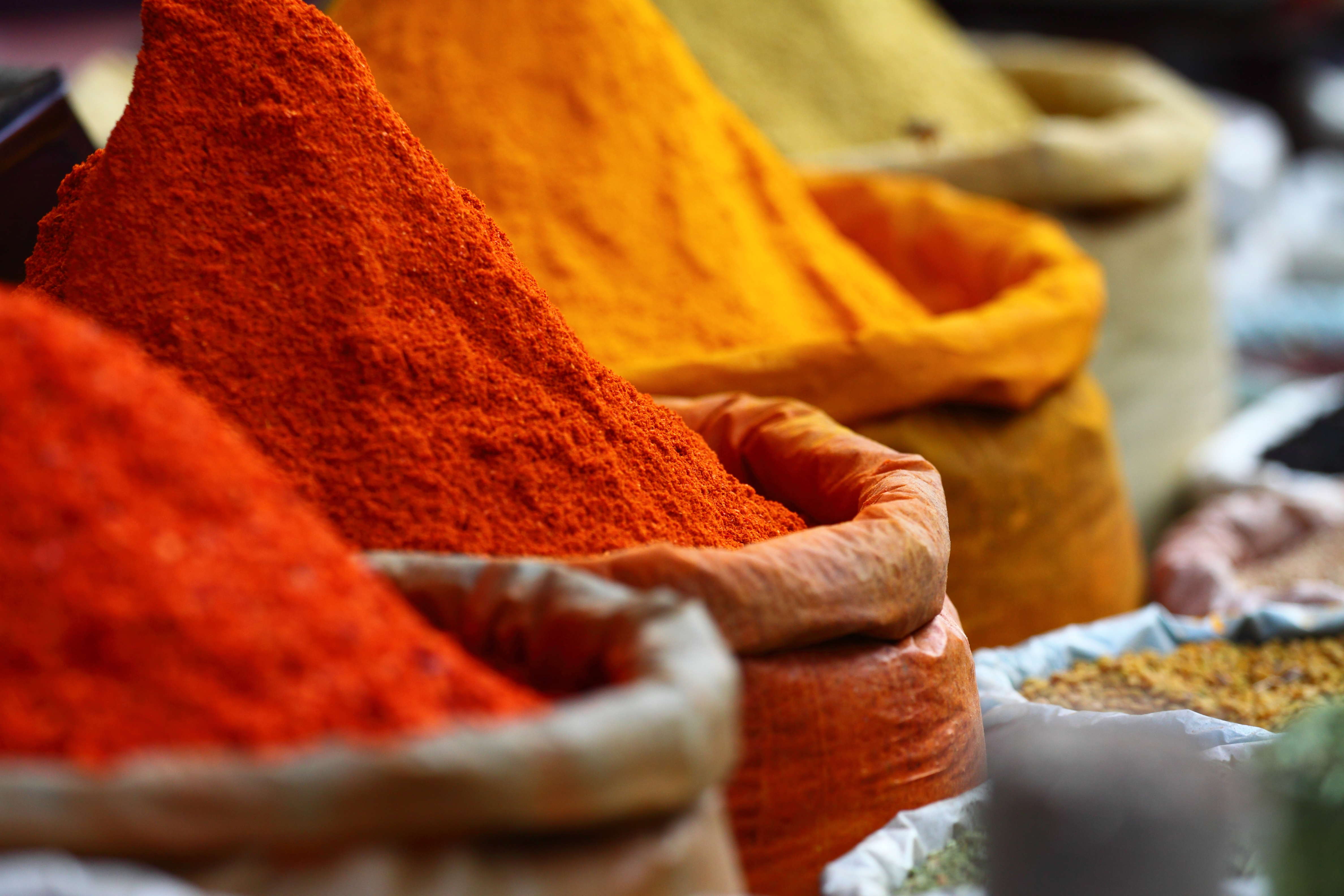 Main Image: Sacks of red, orange and yellow spices.