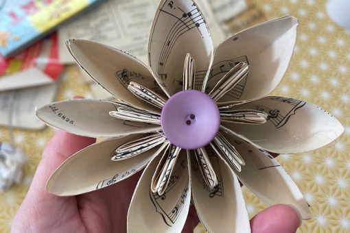 Main Image: Kusudama Origami Paper Flower made from scrap paper/ old sheet music, with a purple button at the centre.