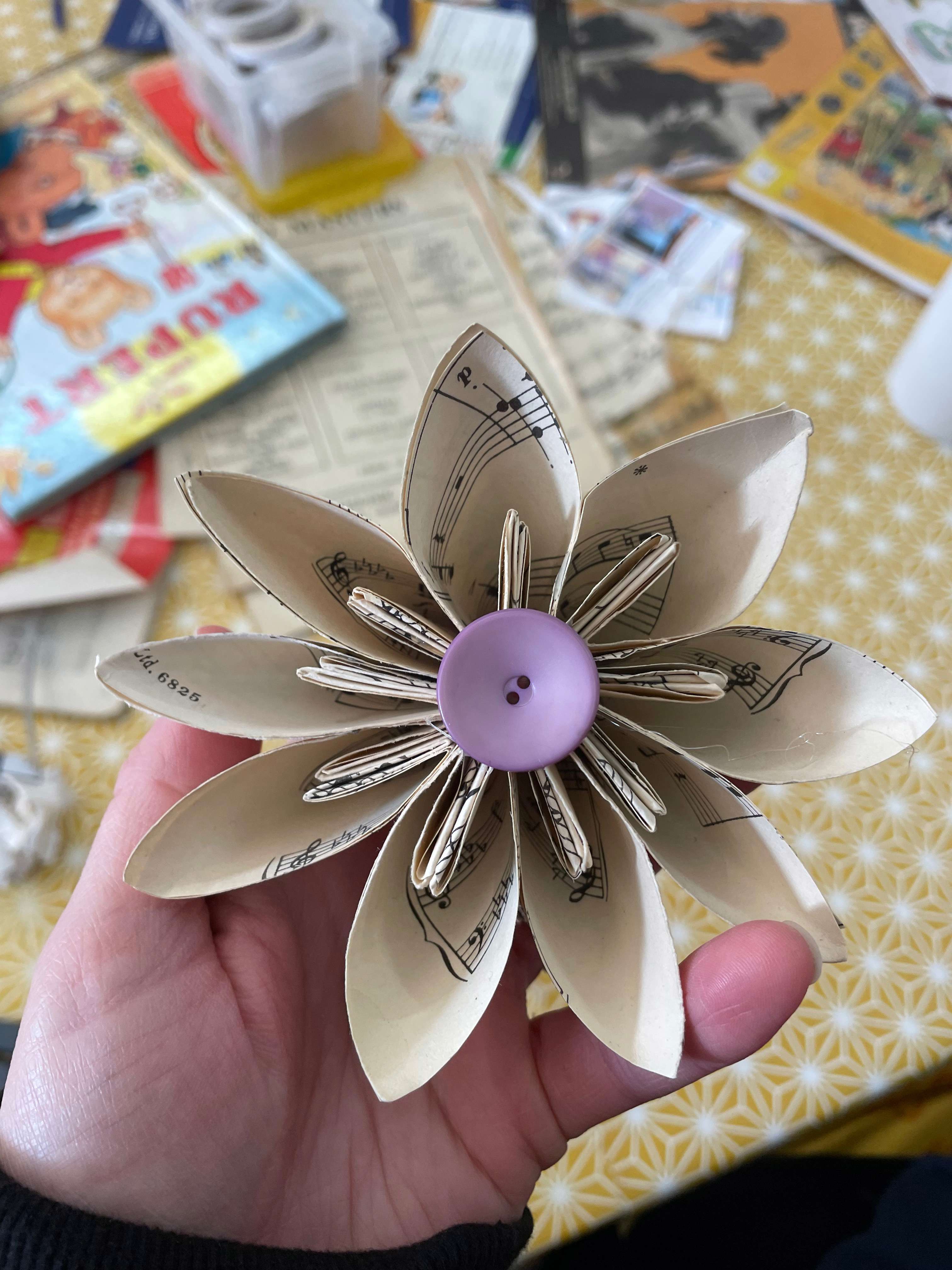Main Image: Kusudama Origami Paper Flower made from scrap paper/ old sheet music, with a purple button at the centre.