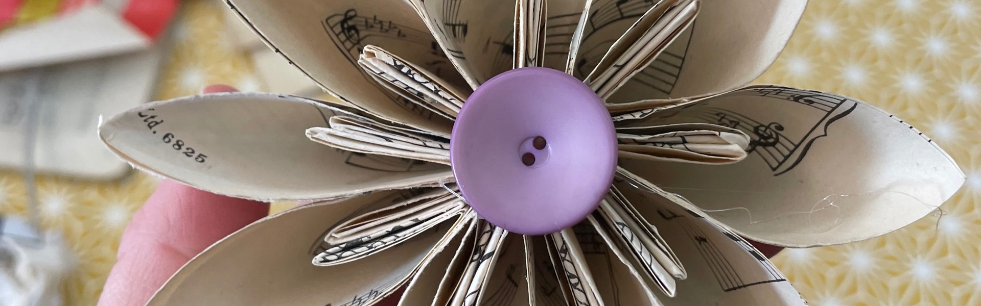 Main Image: Kusudama Origami Paper Flower made from scrap paper/ old sheet music, with a purple button at the centre.