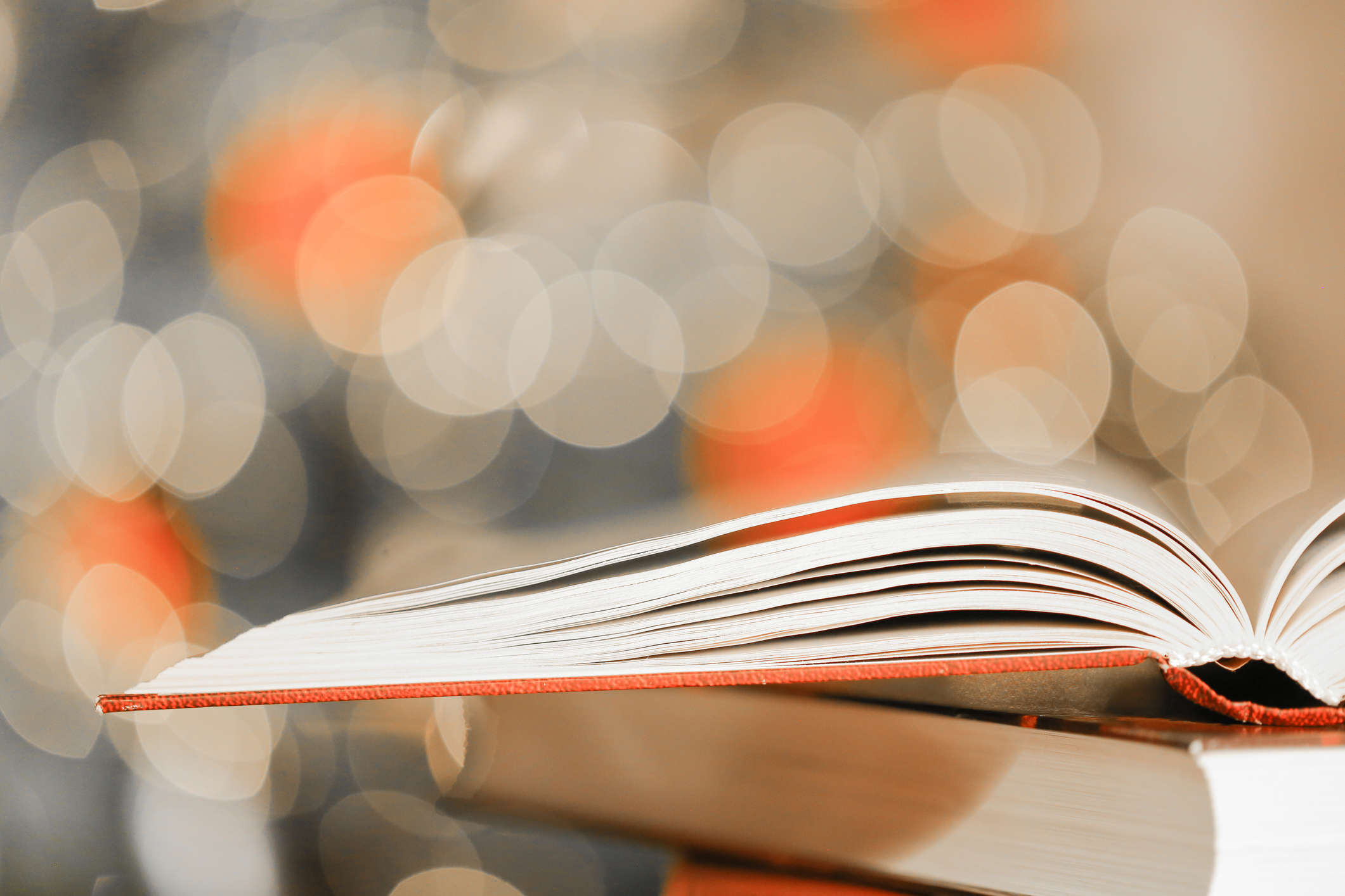 An open story book with festive Christmas lights in the background