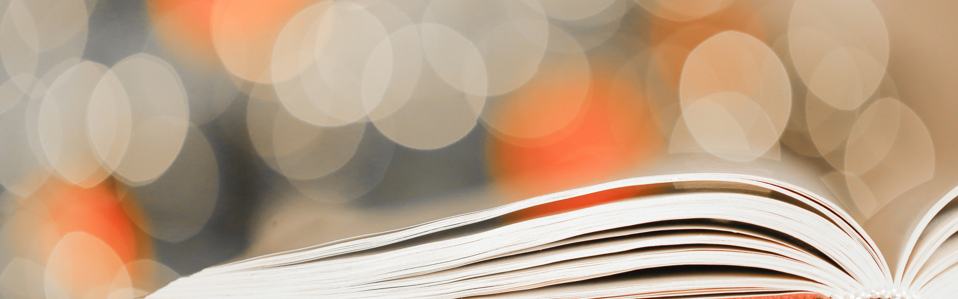 An open story book with festive Christmas lights in the background