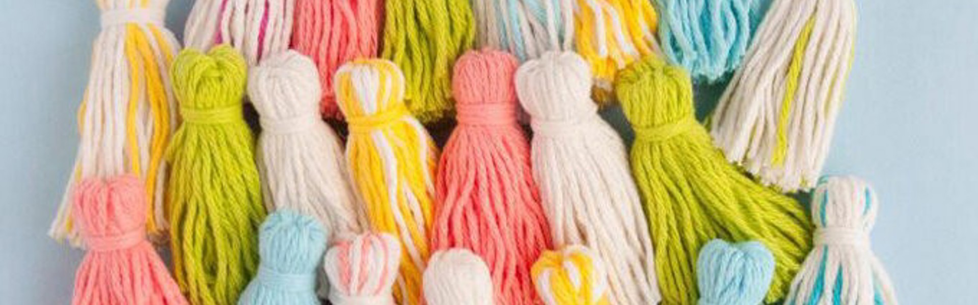 multicoloured yarn tassels on a blue background