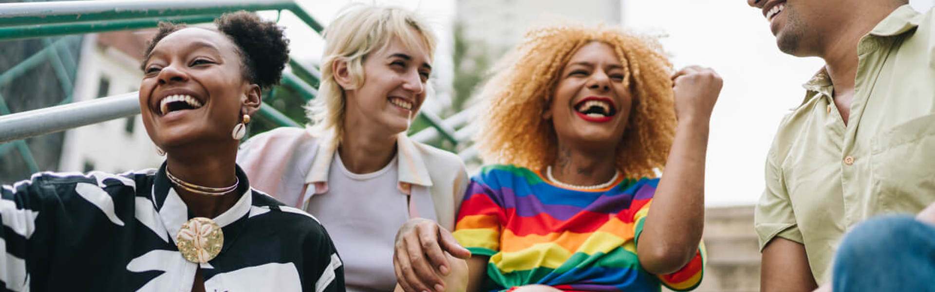 Lgbt+ friends talking sitting on a staircase outdoors