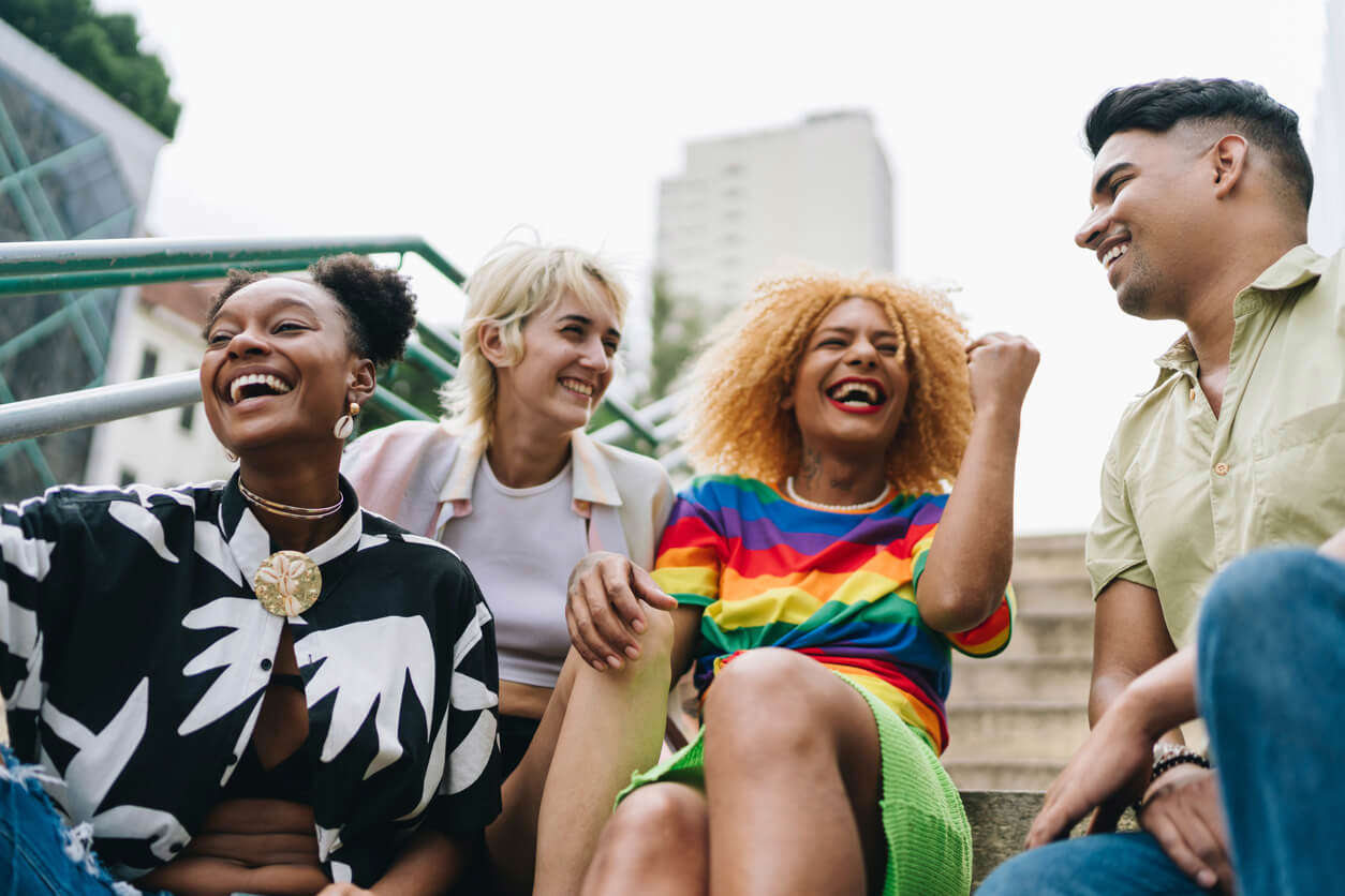 Lgbt+ friends talking sitting on a staircase outdoors