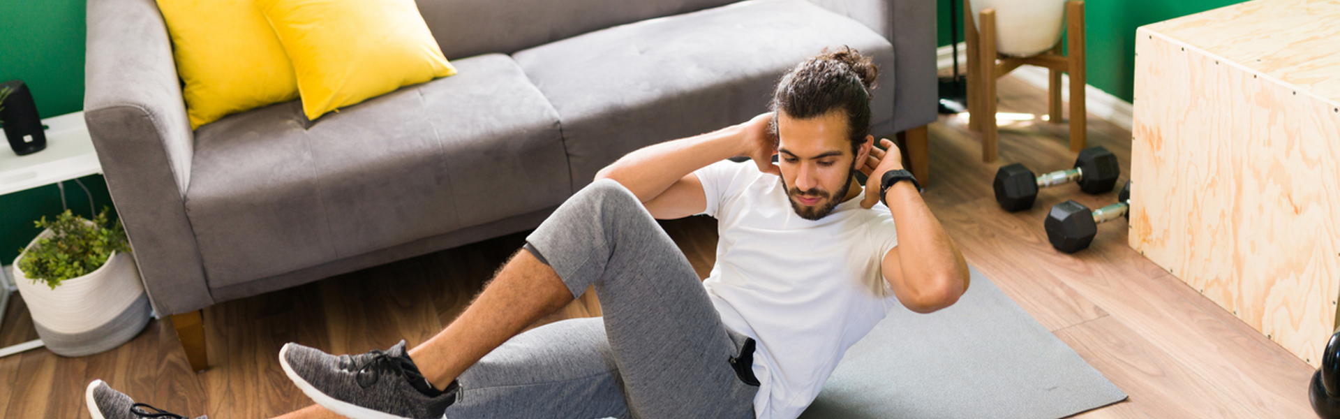 a man completing a HIIT workout at home on a grey yoga matt