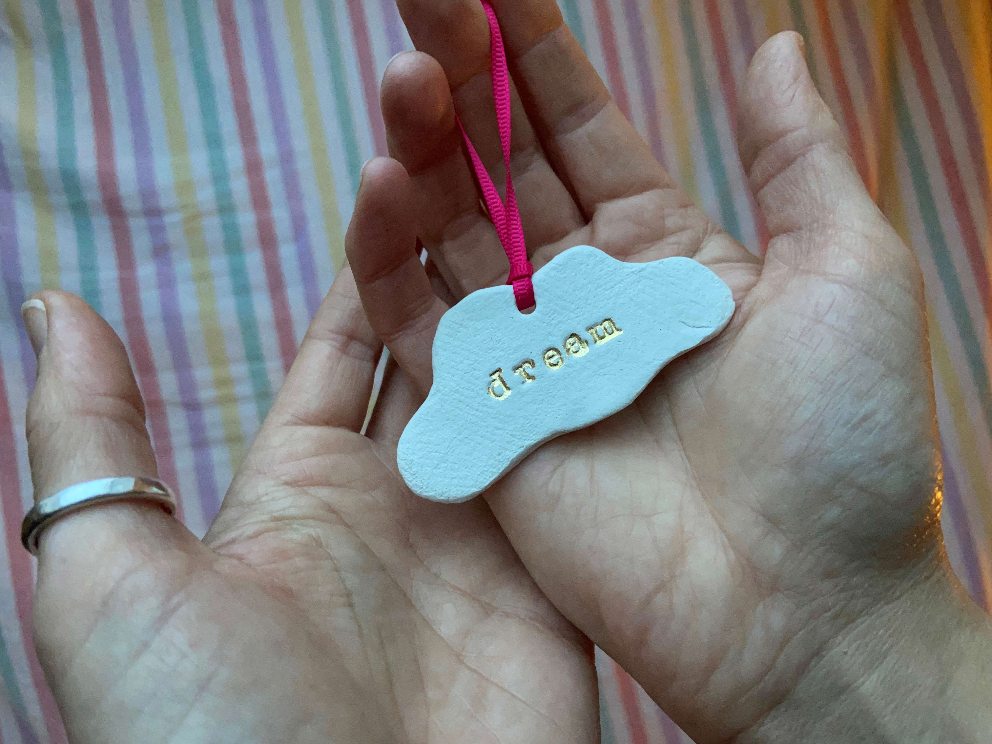 a ceramic cloud keepsake with the word dream engraved into it