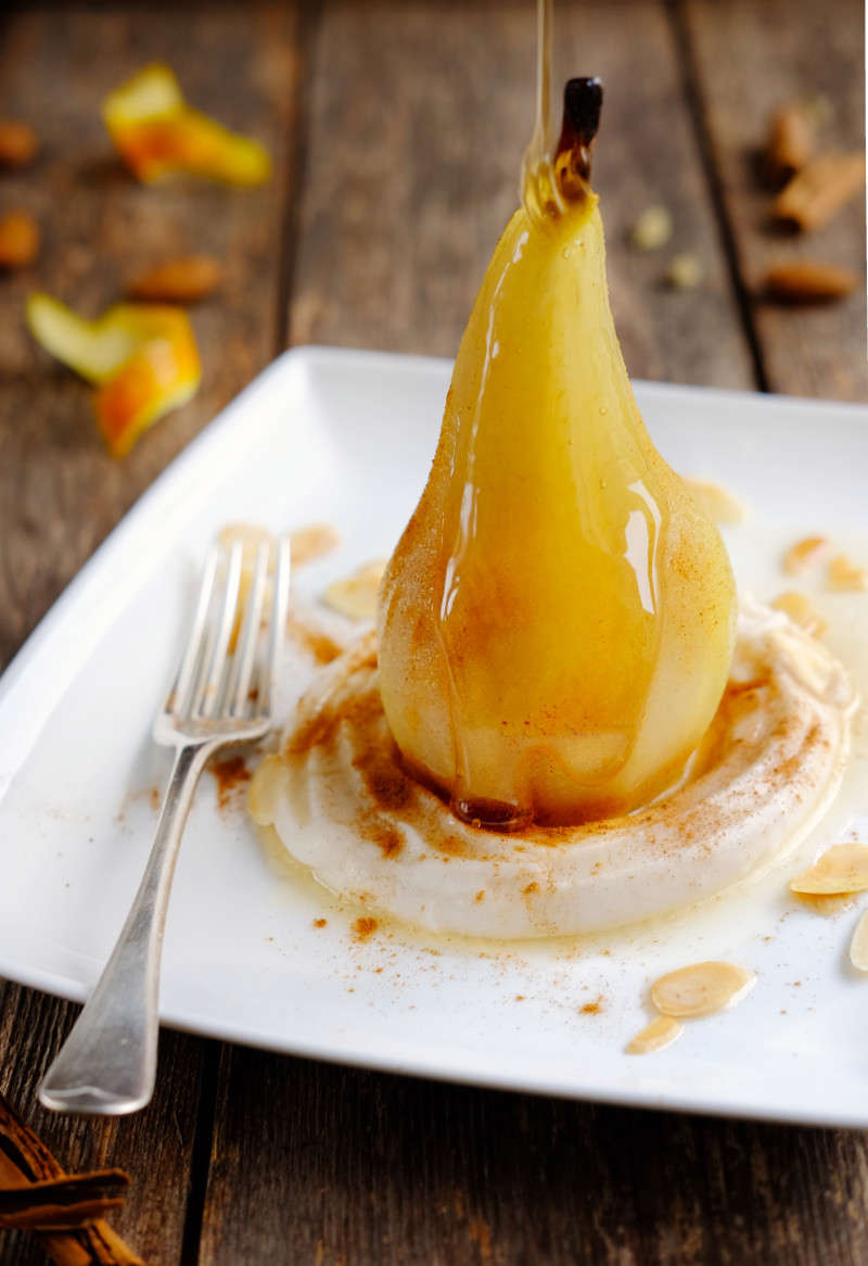 Main image: a vegan Christmas recipe idea - a poached pear on top of maple soft cheese, with a drizzle of maple sauce. 