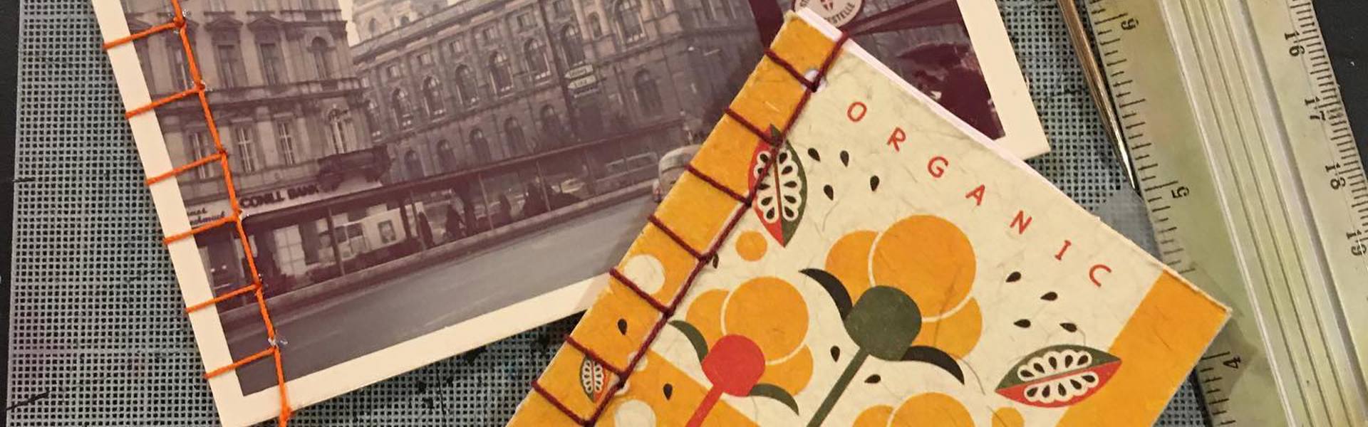Main image: two upcycled notebooks made with Japanese stab binding, one with an old postcard.
