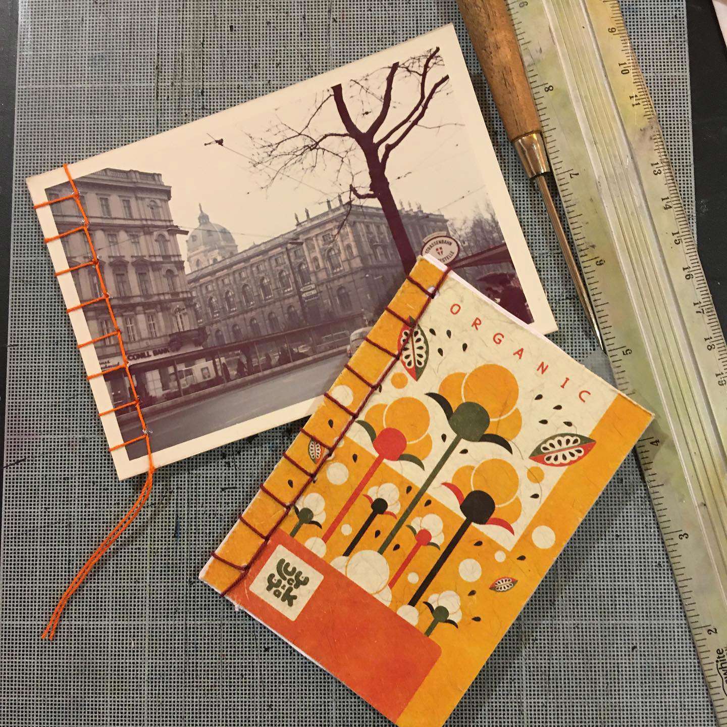 Main image: two upcycled notebooks made with Japanese stab binding, one with an old postcard.