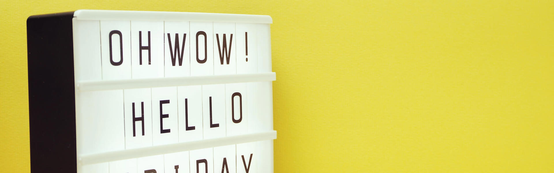 a sign that reads "Oh wow! Hello Friday" against a yellow background