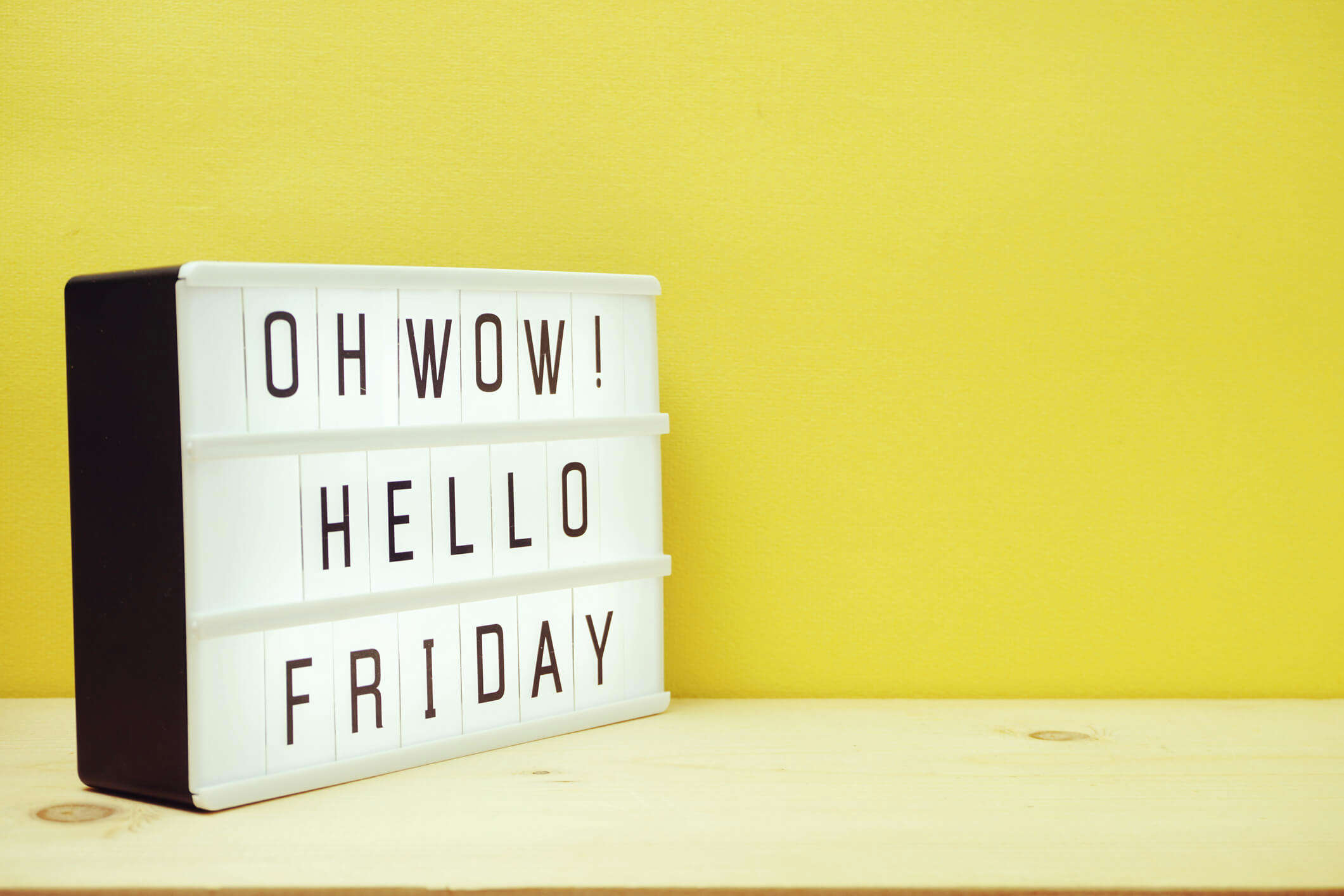 a sign that reads "Oh wow! Hello Friday" against a yellow background