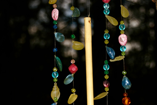 a close up of colourful beads and gems hanging from a wire