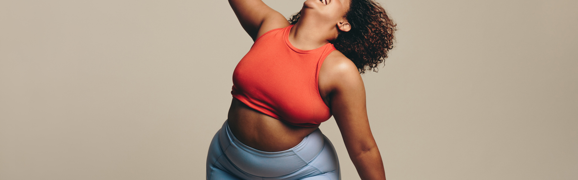 a woman in activewear dancing and laughing