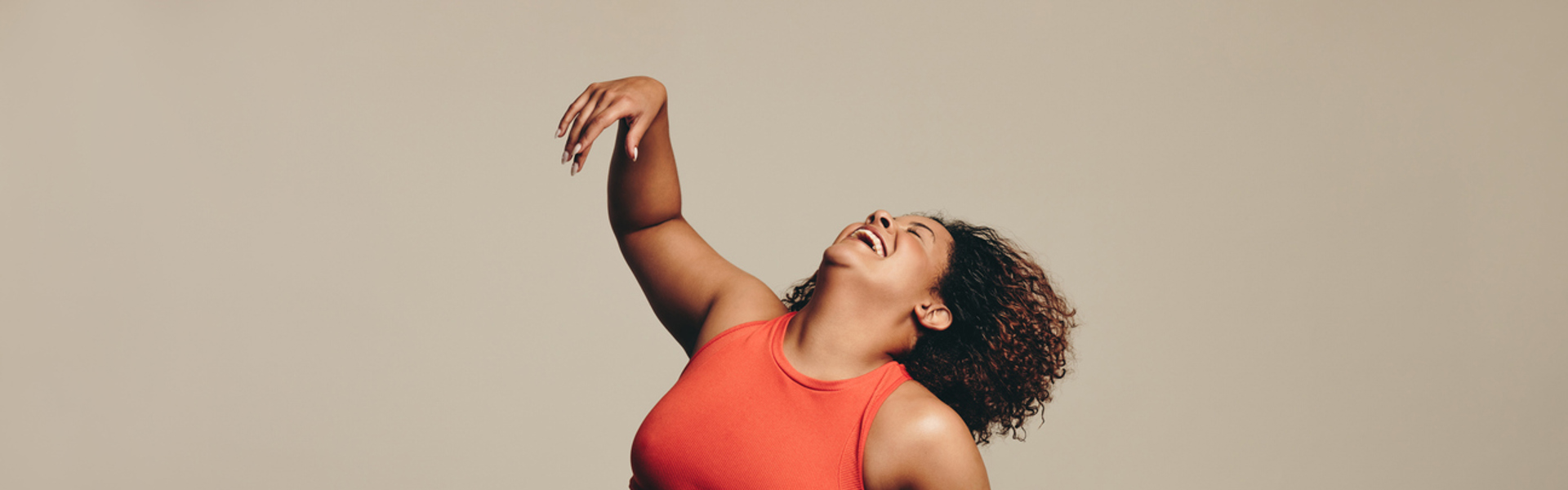 a woman in activewear dancing and laughing