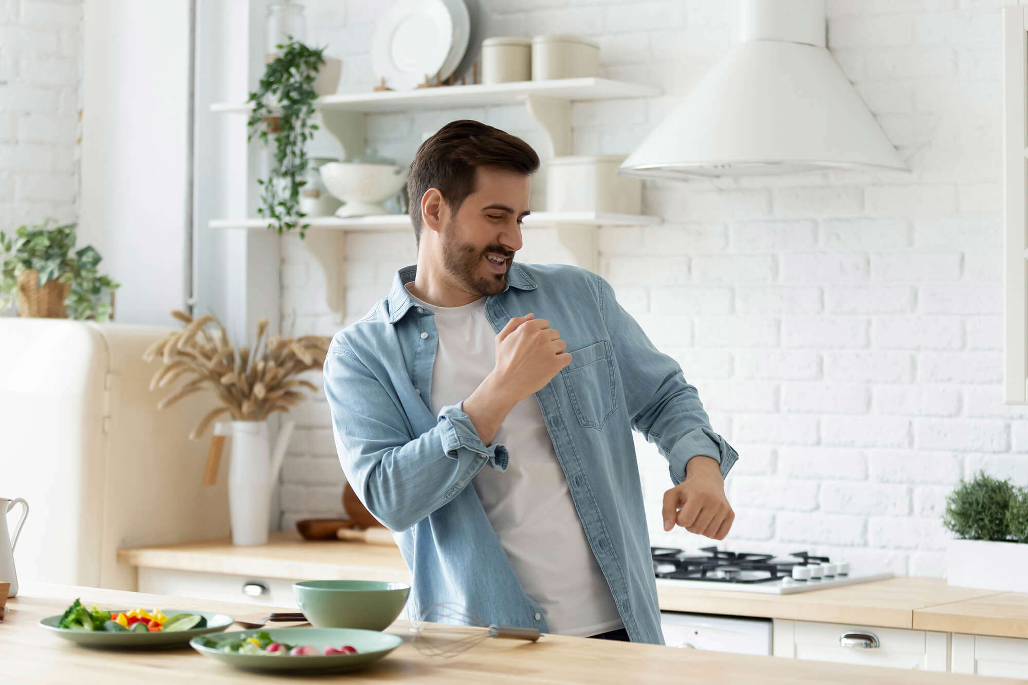 A young man dancing in the kitchen