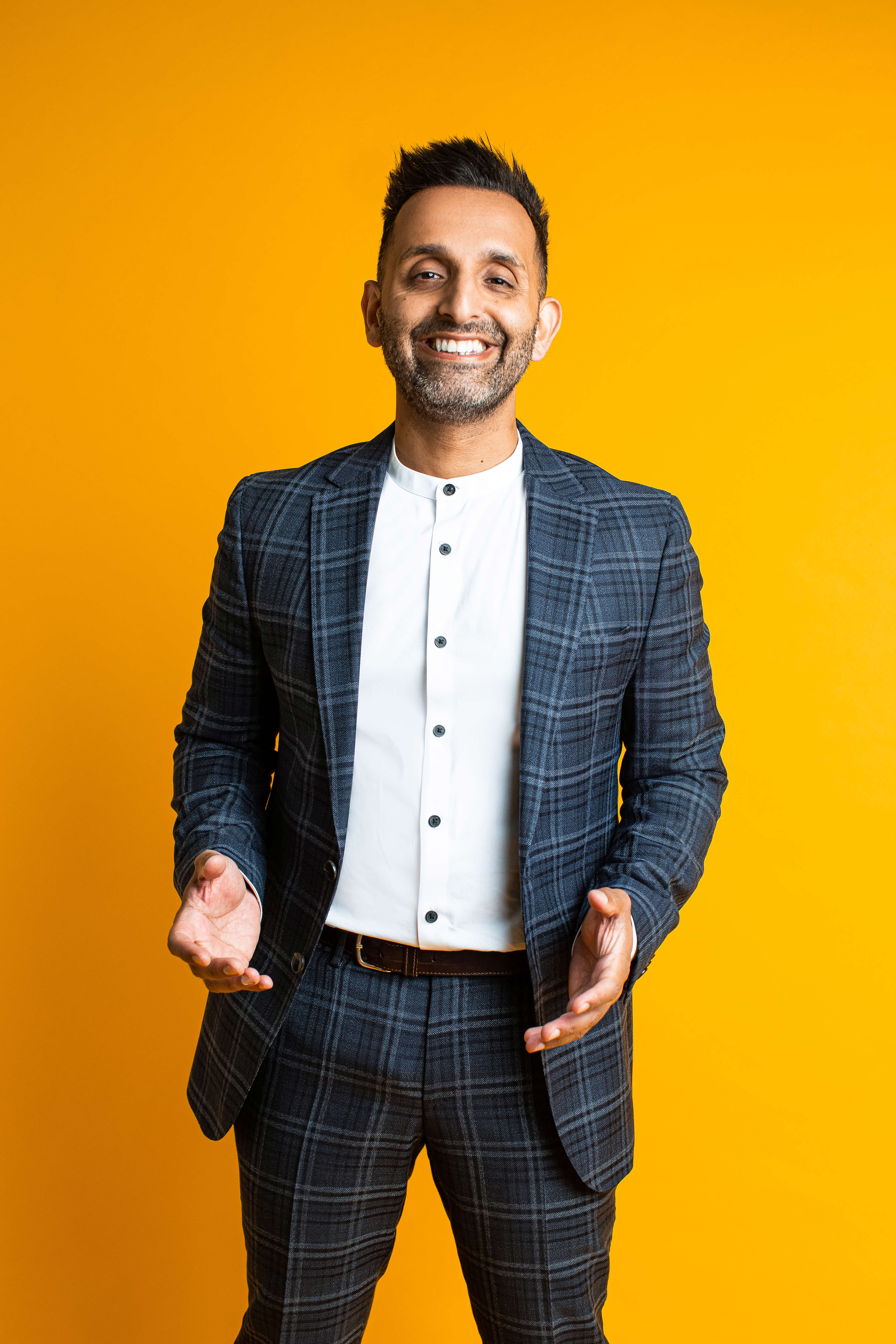 Main Image: a photo of Dr Amir Khan, smiling with a yellow background.