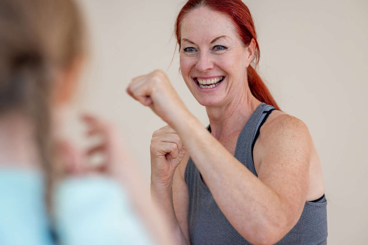 a woman with red hair with her hands up in a boxing position