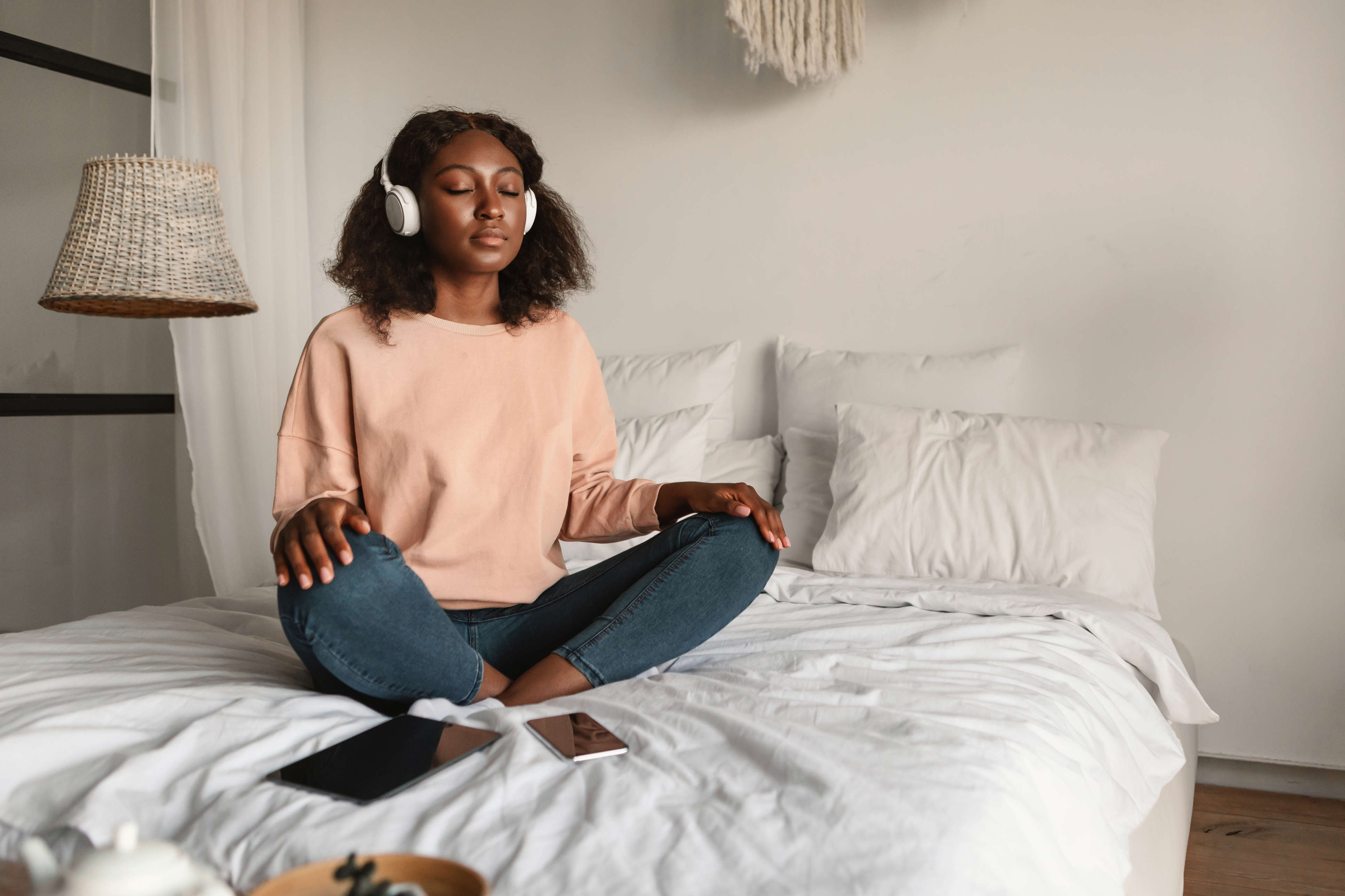 A woman sitting on her bed meditating 