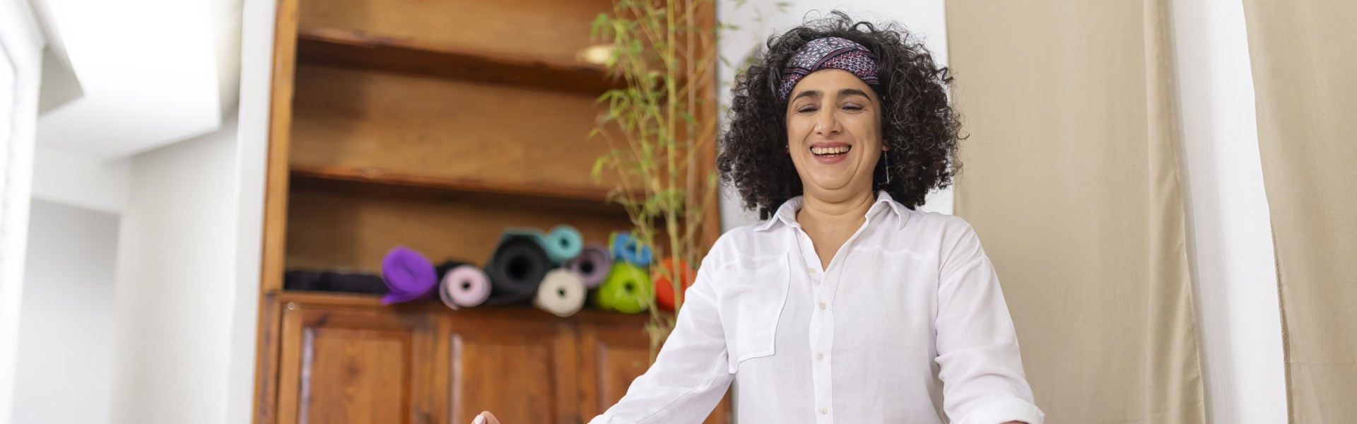 Main image: woman sat at home, taking part in an online meditation or yoga class as part of Mindspace Week!