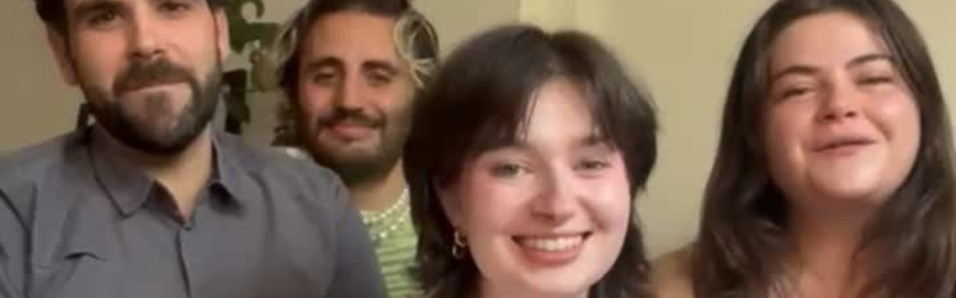 Main image: Ali, Mhairi, Gonçalo and Fran, LGBTQ+ singers from London Contemporary Voices sat smiling at the camera before their a Capella performance of Life On Mars? by David Bowie.