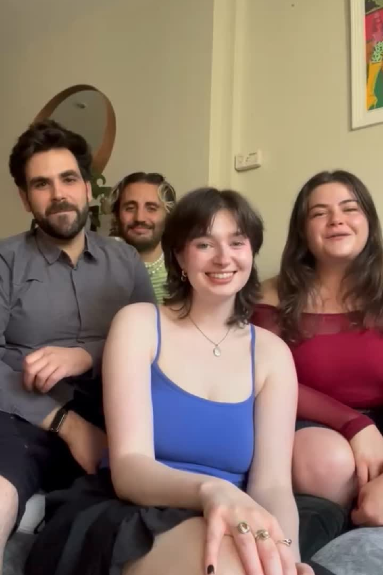 Main image: Ali, Mhairi, Gonçalo and Fran, LGBTQ+ singers from London Contemporary Voices sat smiling at the camera before their a Capella performance of Life On Mars? by David Bowie.