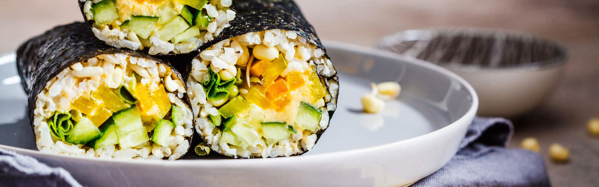 a close up of three vegan sushi rolls on a plate